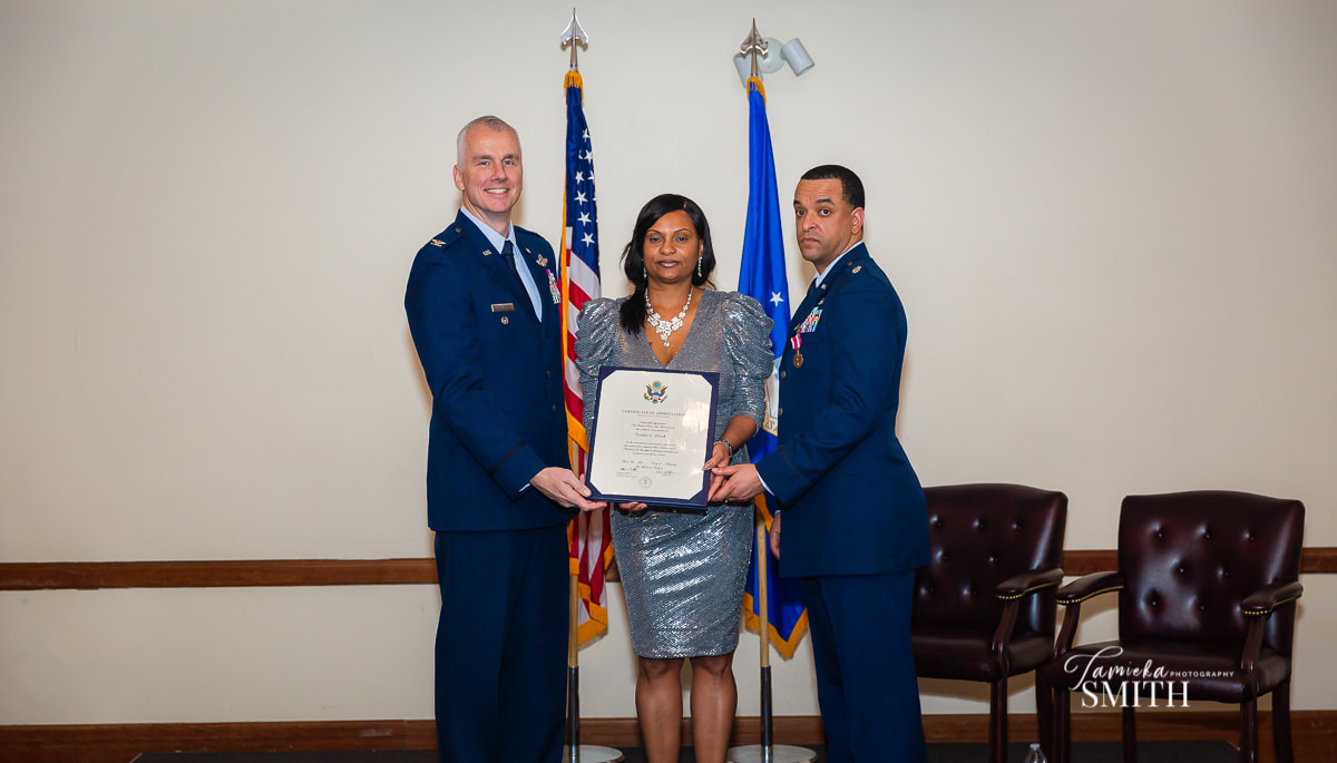 Air Force Spouse receiving spouse appreciation certificate.