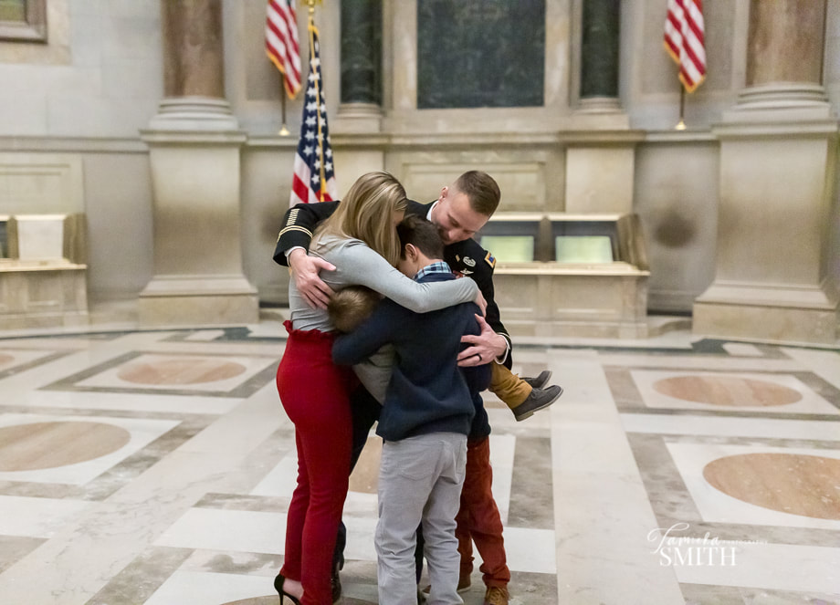 Army member giving a group hug to his children
