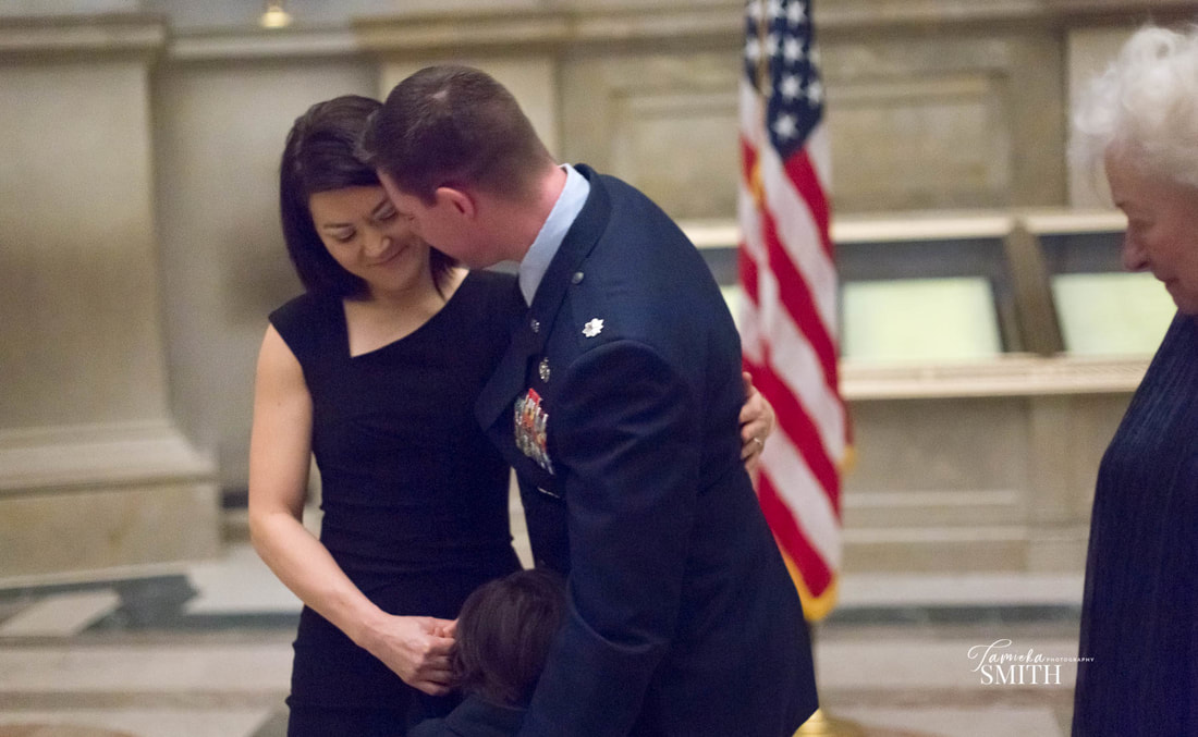 wife hugging Military Officer at the National Archives museum