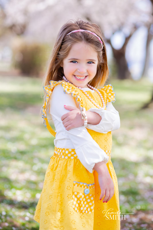 Young girl in yellow and white dress with the Cherry Blossoms in Washington DC with Los Angeles Family Photographer