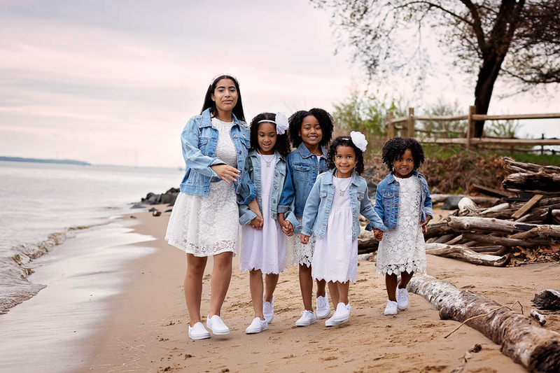 Admire the beauty and grace captured in this stunning photograph of two cousins walking along the Potomac River at the Leesylvania State Park in Woodbridge, VA, taken by the talented Woodbridge family photographer Tamieka Smith. The cousins' matching white dresses and blue jean jackets create a sense of unity and harmony, while their confident and carefree expressions convey a sense of joy and freedom. Tamieka's skillful use of light and color creates a sense of serenity and peace, with the natural beauty of the Potomac River and the verdant forest surrounding the cousins, enhancing the photo's calm and gentle tone. This photograph is a tribute to the beauty of nature, the power of family, and the simplicity of childhood. It's a treasure that the cousins and their family will cherish for years to come, a symbol of the peace and serenity that can be found in the beauty of the great outdoors and the love of family.