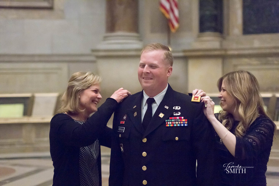 family putting new rank on military officer in national archives