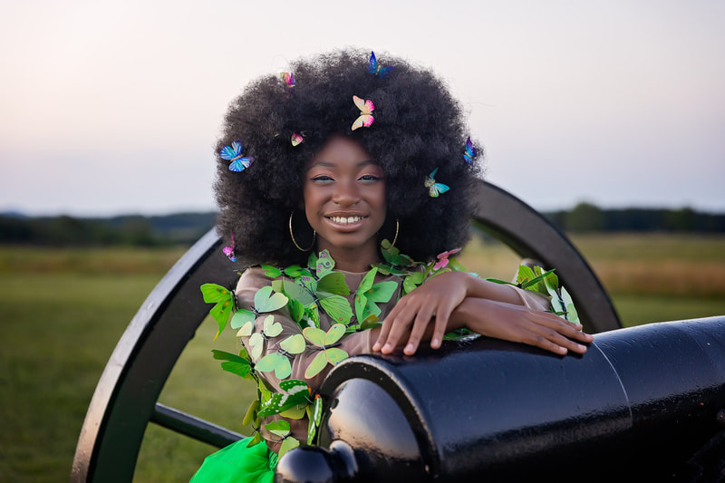 Northern Virginia Family Photographer Tamieka Smith at Manassas Battlefield Park photographing a girl with a butterfly dress and butterflies in her hair