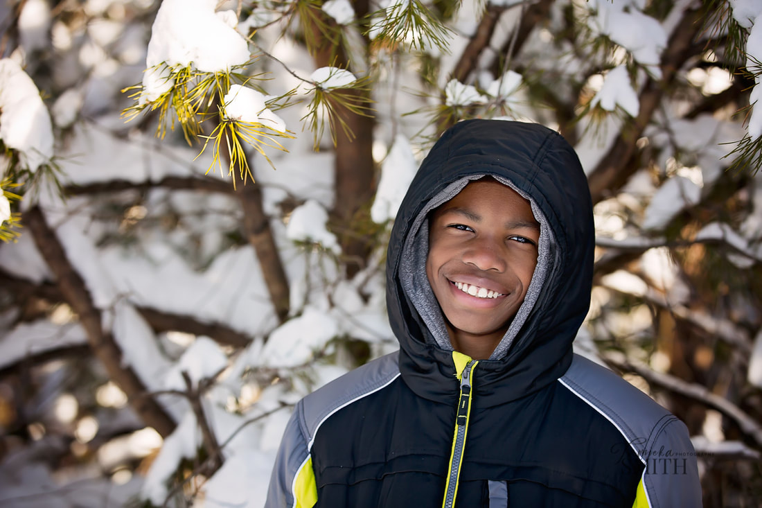 Photographing a kid smiling in the snow in Northern Virginia by Tamieka Smith Photography